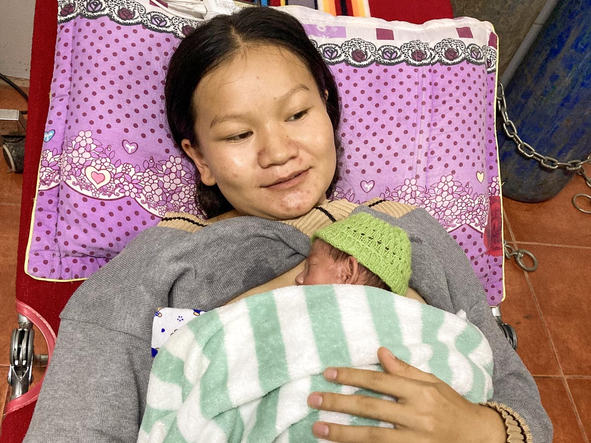 Laotische Mutter mit ihrem neugeborenen Kind