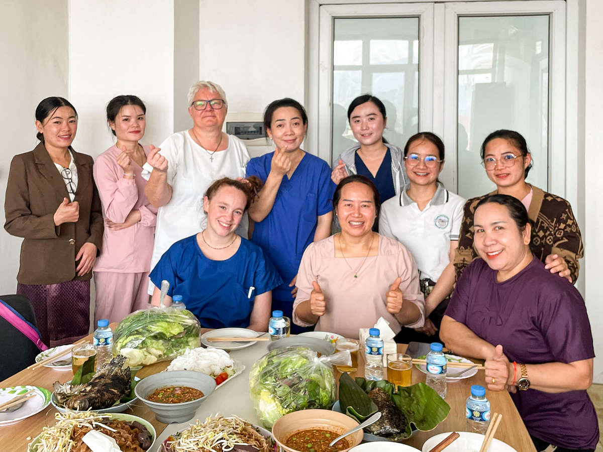 Group photo showing women in hospital gowns with a laid table