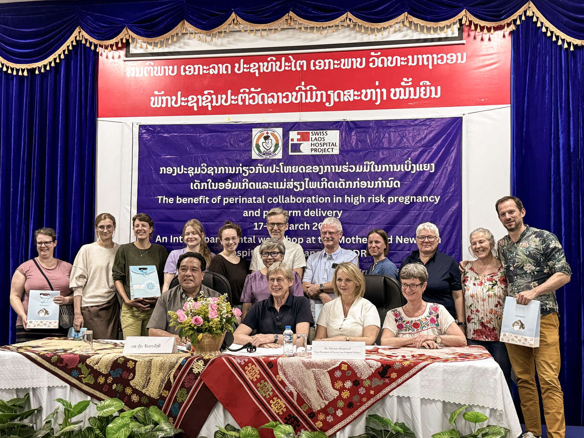 Group photo showing participants with a banner in the background