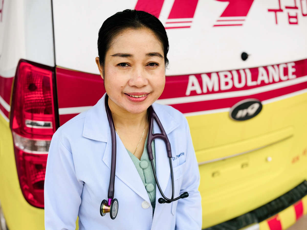 Portrait of a Laotian doctor in front of an ambulance