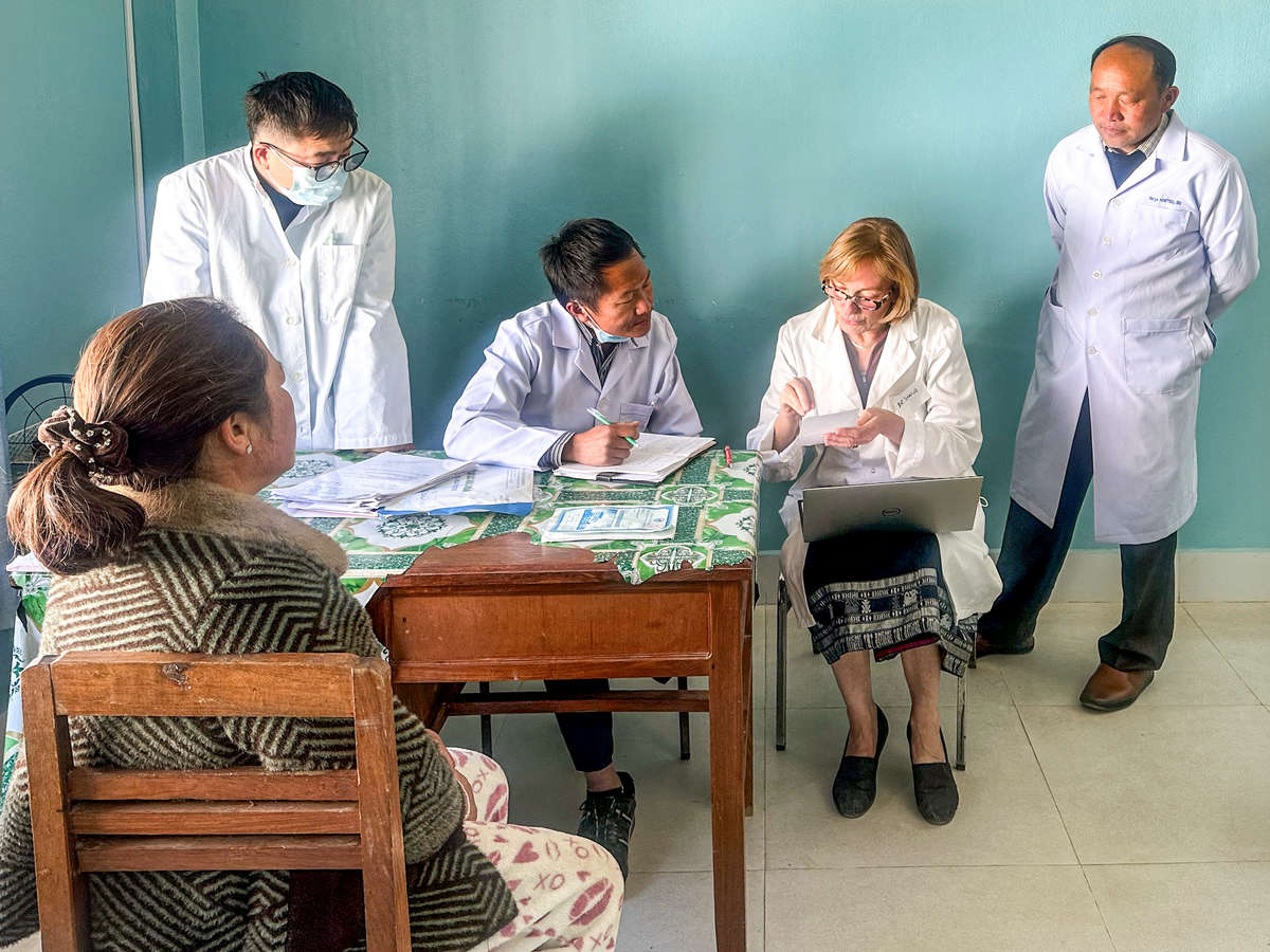 A group of doctors talking to a patient