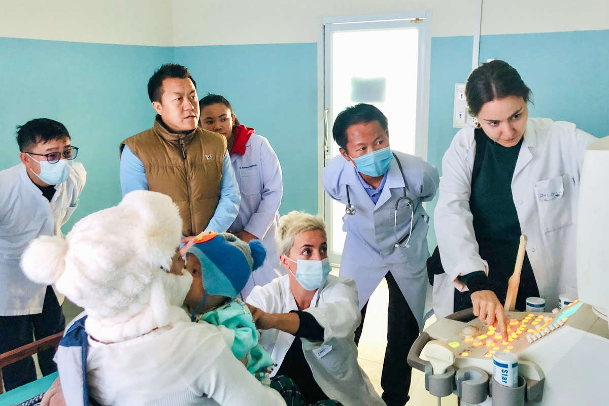 A group of doctors are examining a child using an ultrasound scanner